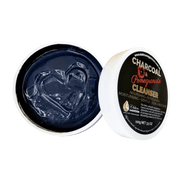 Open container of charcoal-based cleanser with visible branding 