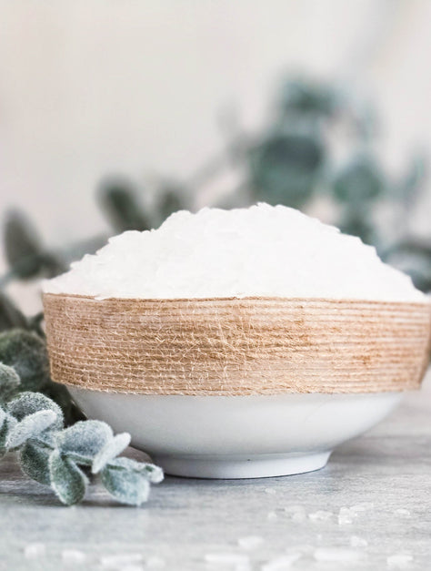 Bowl of white magnesium flakes on a surface with blurred background